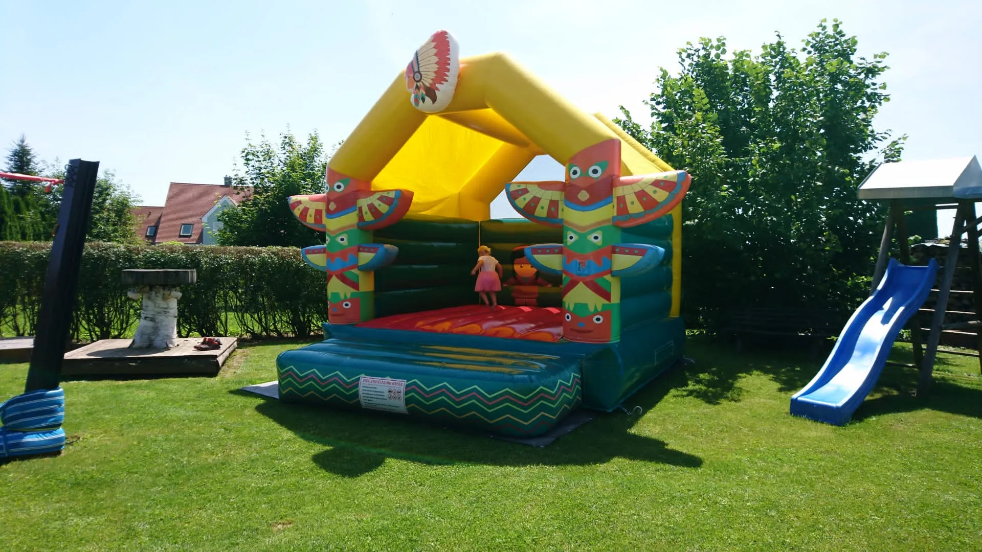 Kinder spielen auf einer Hüpfburg im Garten