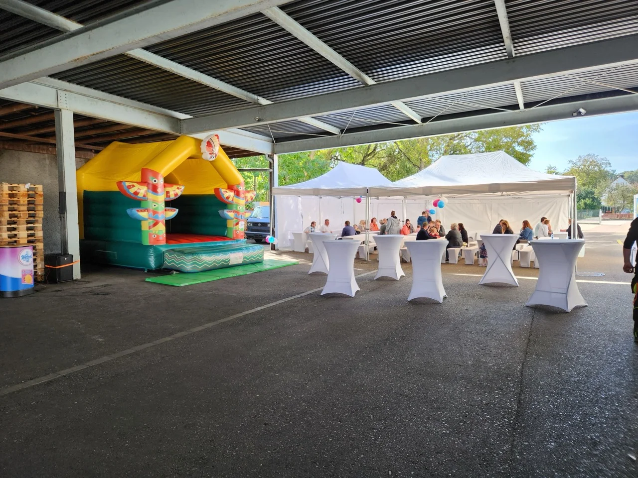 Eventhalle mit Hüpfburg und Stehtischen